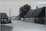 Foto taget fr stergade blev rettet ud som vi kender den i dag. 
Til venstre ses det strtgte bindingsvrk som stadig ligger der. Huset i hjre side er revet ned til fordel for gennemfrsel af stergade. Efter VW Folkevognen anes forretningen TATOL, som senere blev overtaget af el-installatr Alf Katholm. S kommer huset som vi kender det p hjrnet af stergade og Syrenvej. Derefter Laurbjerg Tmmerhandel og sidst Kageboden.
Det er uvis hvornr stergade blev rettet ud, men angiveligt i perioden 1962  1963.